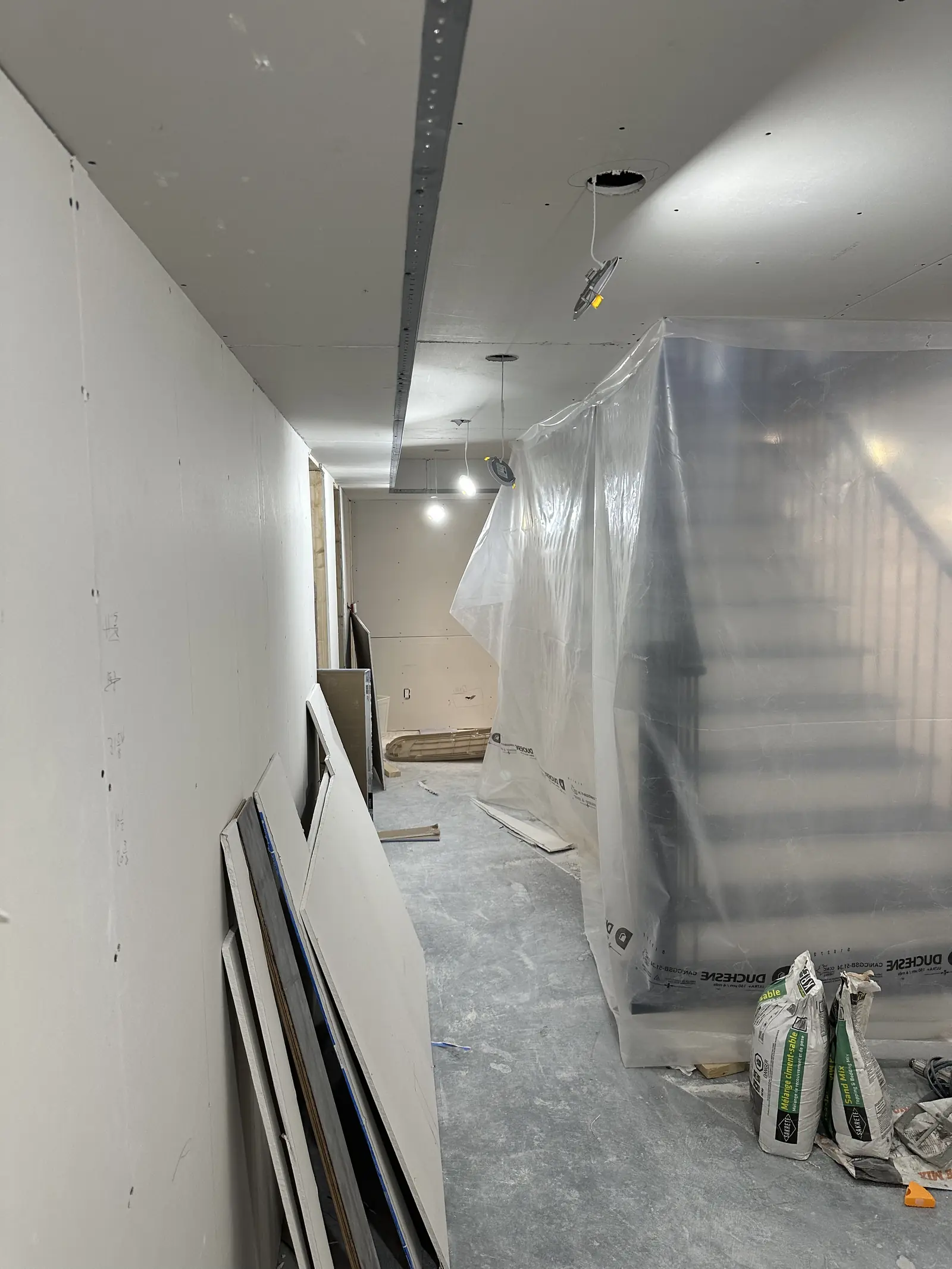 Drywalled basement and stairs partway through the build
